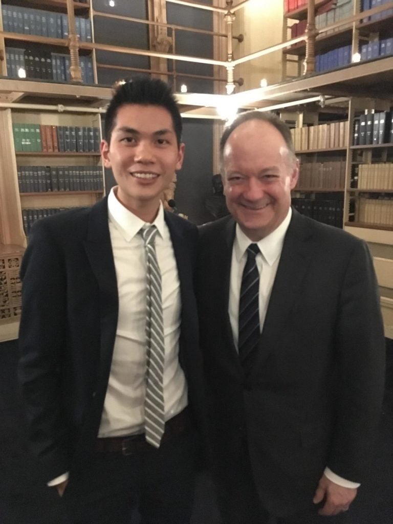 Mark Lee '17 poses with GU President DeGioia, PhD at a graduate student recognition dinner. 
