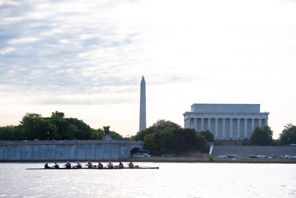 students rowing on the Potomac river in front of the Lincoln Memorial and Washington Monument