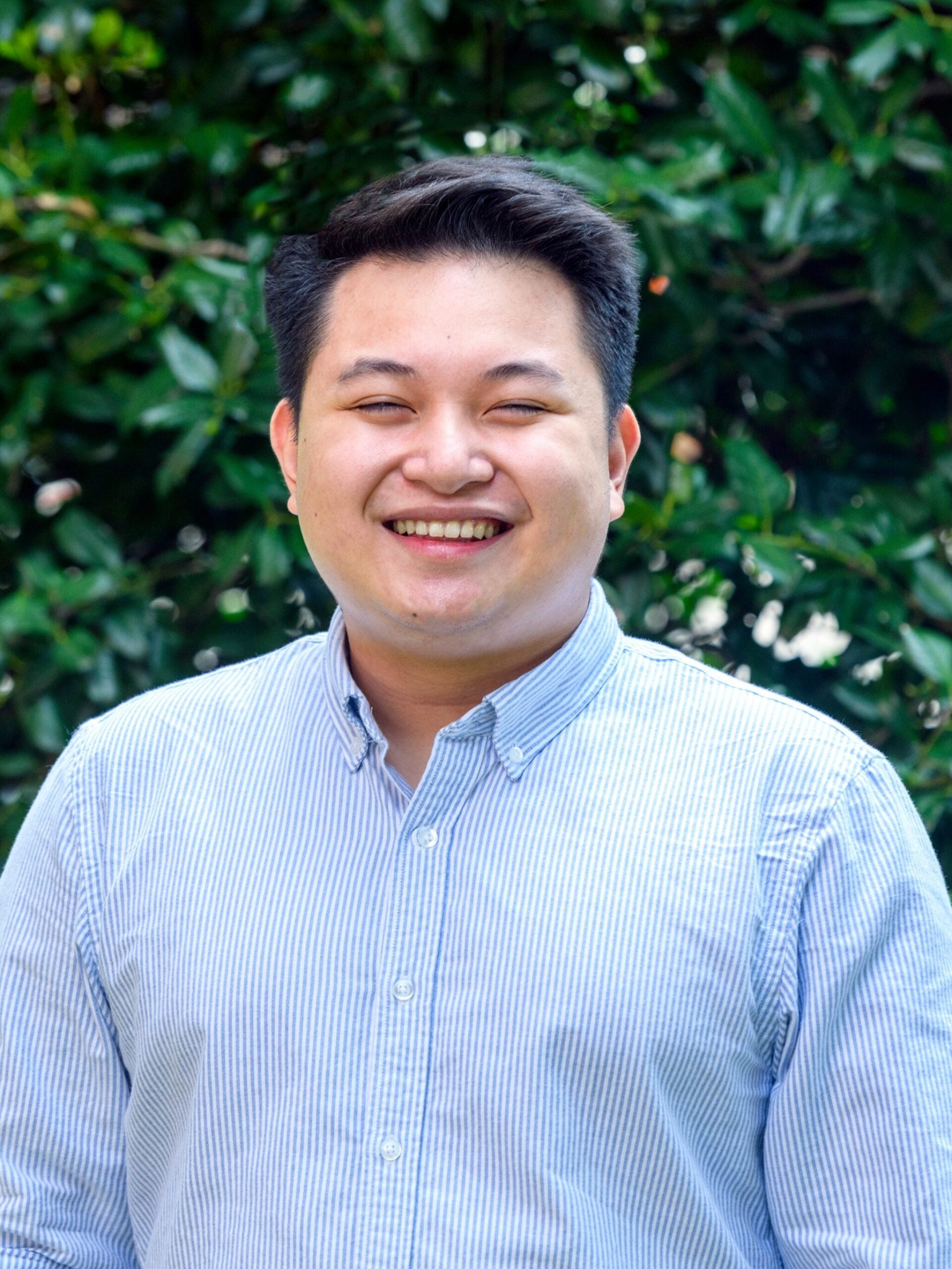 Headshot of Francis Thaddeus Lazaro standing in front of greenery, Alumnus of M.S. Global Health